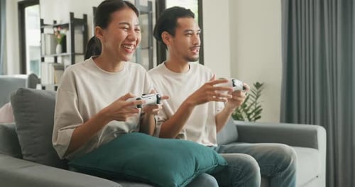 Enthusiastic Couple Enjoying Video Game on Living Room Sofa