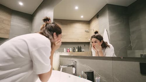 Woman Washing Face in Modern Bathroom