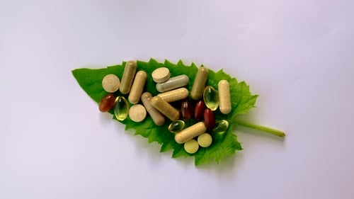 Variety of Pills and Capsules on a Leaf
