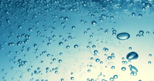 Many water bubbles in blue water close up, abstract water wave with bubbles in slow motion.