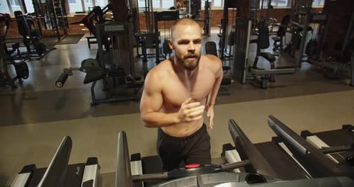 Handsome Athletic Guy Working Out Treadmill While Working Out in the Gym Alone