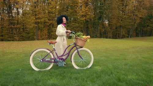 Woman Walking Bicycle in Autumn Park