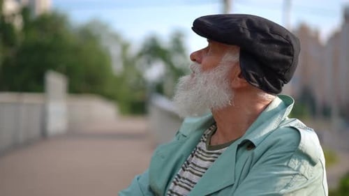 Side View Portrait of Smiling Relaxed Male Retiree Standing Outdoors Looking Around in Slow Motion