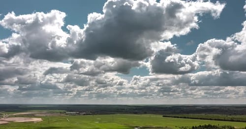 A Vast Expansive Green Landscape Spreading Out Under Dramatic and Beautifully Cloudy Skies Above