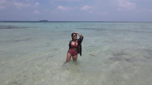 Aerial view of an Asian woman wearing bikini having a fun holiday at the beach in Karimunjawa