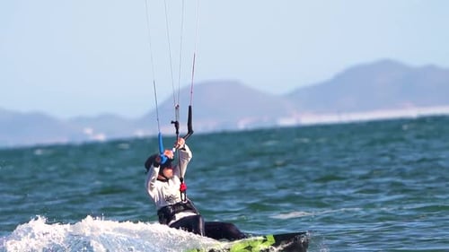 Sportsman practicing kite surf sport at the beach on a windy day