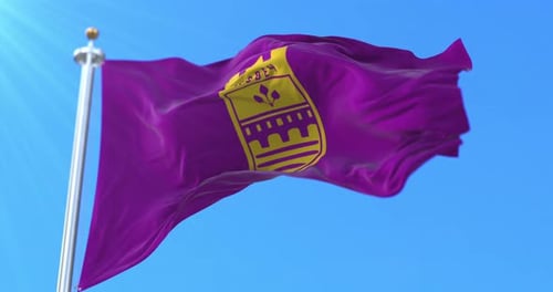 Purple Flag With Yellow Emblem Waving in Blue Sky