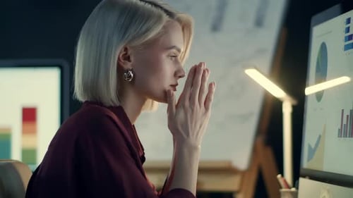 Tired businesswoman analyzing financial statistics in night office workplace