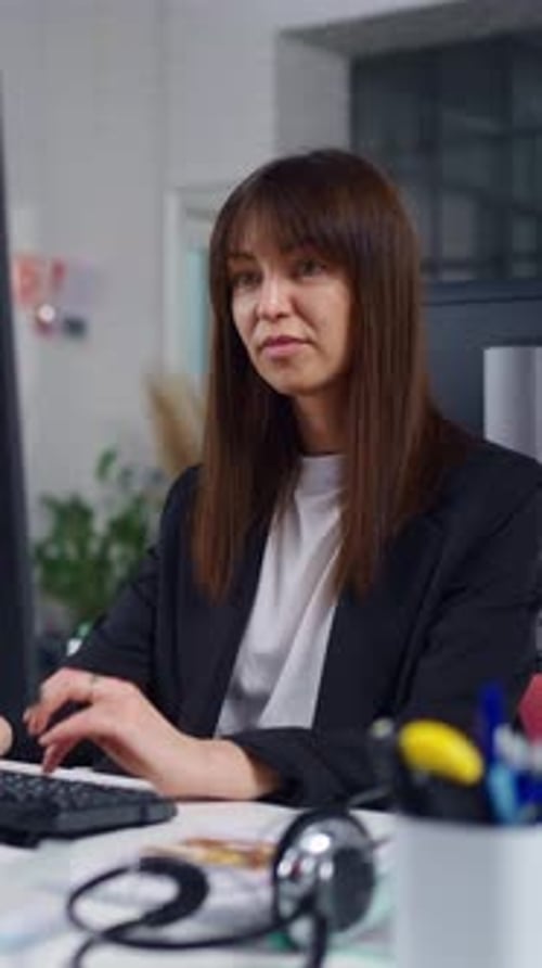 Focused Professional Woman Working on Computer in Modern Open Plan Office Typing at Desk While