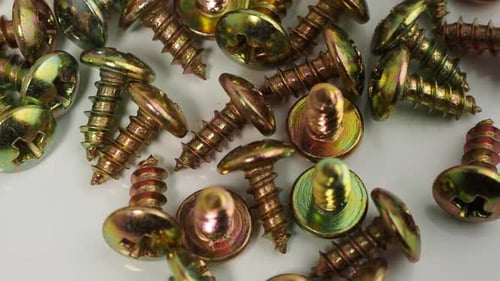 Metal screws on a white background. Rotating screws for driving into plastic.