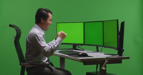 Happy Man Celebrating And Dancing While Working With Mock Up Multiple Monitor In Green Screen