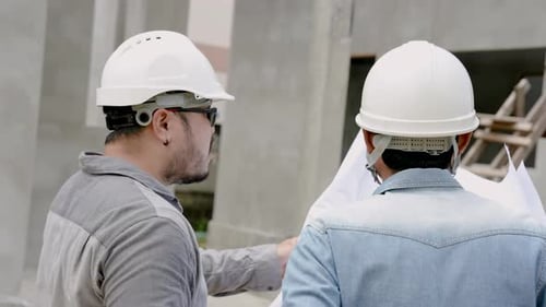 Engineers Reviewing Blueprints at Construction Site