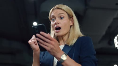 Excited Woman Celebrating Success with Mobile Phone