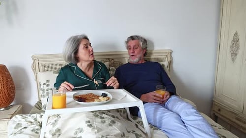 Senior Couple Enjoying Breakfast Together in Bed