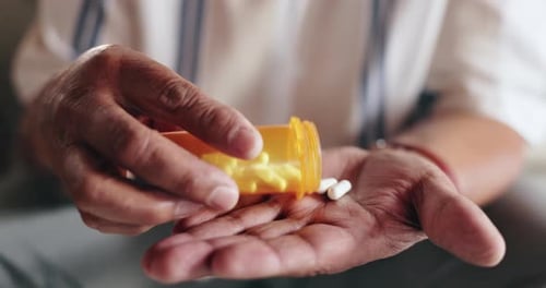 Senior Hand Pours Pills Into Wrinkled Palm