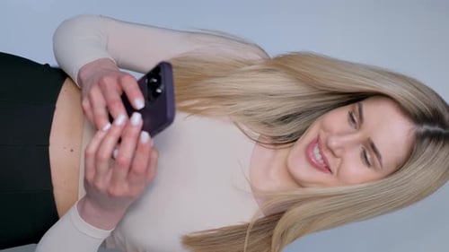 Woman Smiling at Smartphone in Portrait Video