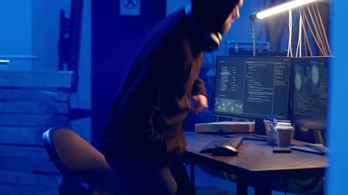 Hooded Hacker Creating Pirating Crack for Software and Video Game Releases