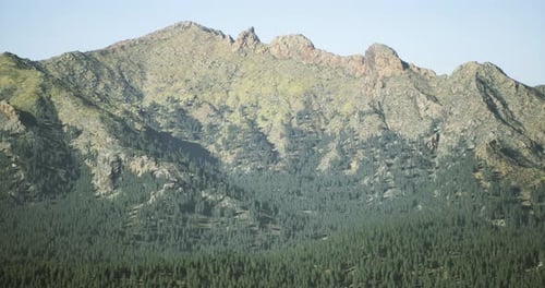 Majestic Mountain Range with Lush Greenery in a Clear Sky Setting