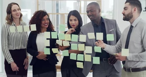 4k video footage of a group of businesspeople brainstorming with notes on a glass wall in an office