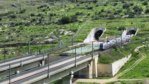 Un train de voyageurs des chemins de fer israéliens traverse le pont ferroviaire de la vallée verte d'Arazim par une belle journée