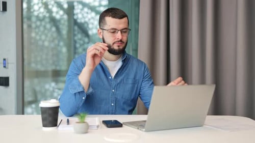 Man Working at Desk Takes a Break