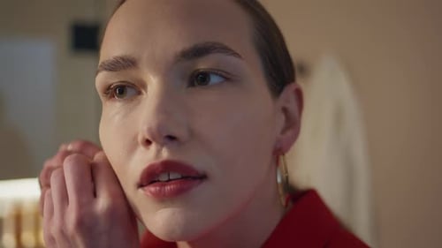 Woman Fastening Gold Hoop Earring and Smiling