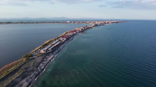 Aerial View of the Shore with Grass and Houses Surrounded By the Black Sea Under a Clear Sky in