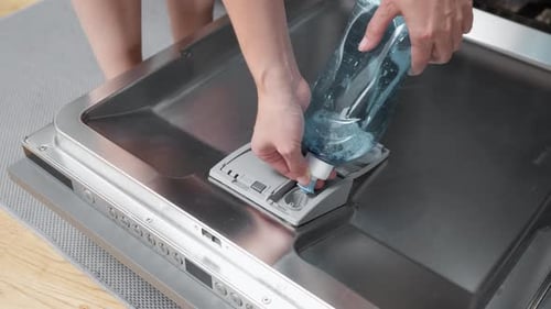 Verser le liquide de rinçage dans le distributeur du lave-vaisselle avant le cycle de lavage