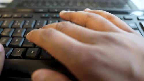 An individual Typing on computer keyboard, captured in a close-up video, symbolizing the realm of di