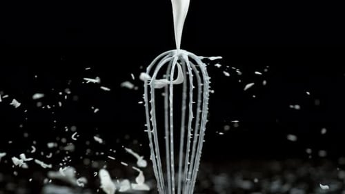 Pouring Thick Cream Over a Whisk in Slow Motion