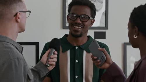 Smiling Black Man Giving Interview to Reporters
