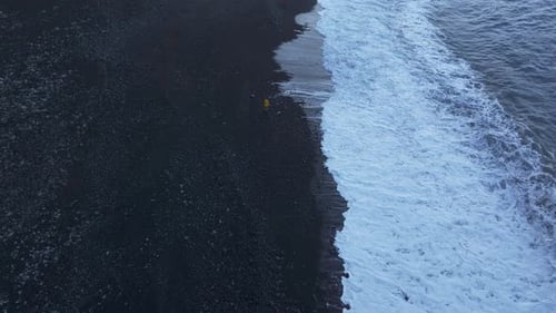 Aerial view of tranquil black sand beach at sunrise, Portugal.