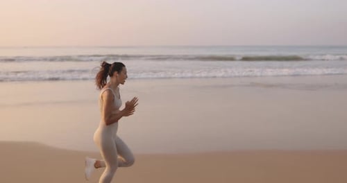 Female Runner Jogging During Outdoor Workout on the Beach in Slow Motion