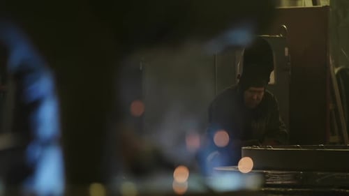 Welders Working in Dark Industrial Space