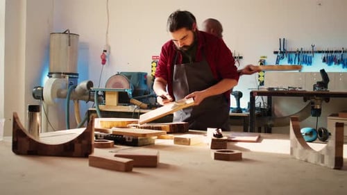 Un menuisier dans un atelier d'assemblage entame un projet de rénovation sur une planche de bois