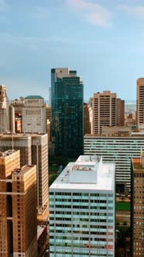 Tops of skyscrapers towering above multi-storied buildings of Philadelphia cityscape. Vertical video