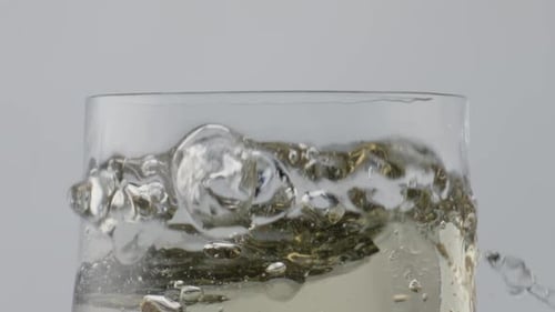 Ice Cube Falling Sparkling Alcohol Drink in Super Close Up