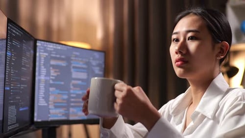 Nahaufnahme einer Programmiererin, die Kaffee trinkt, während sie eine Software-Ingenieurin entwickelt, die eine App entwickelt