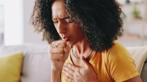 Sick Woman Coughs at Home on Couch