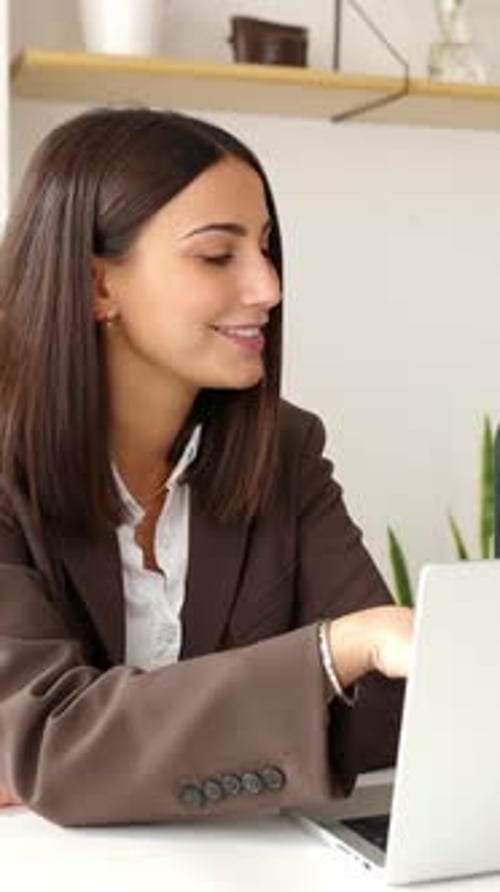 Smiling Young Woman Working on Laptop