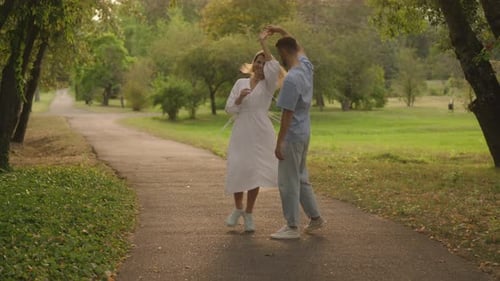 Happy Couple Dancing in the Park on a Summer Day