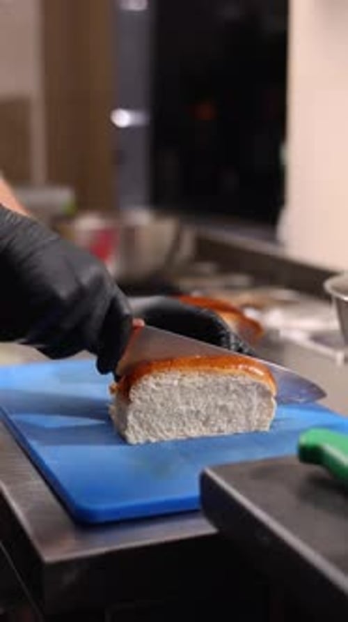 A chef prepares delicious hot dogs in a restaurant.