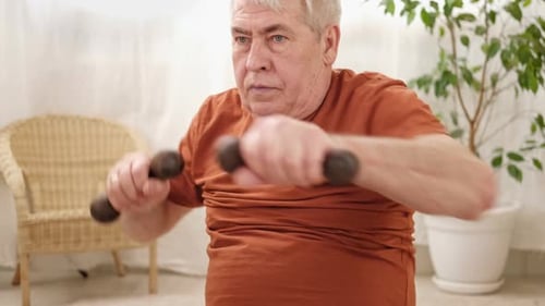 Mature Adult Exercising with Dumbbells Indoors