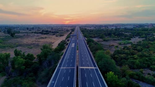 Vehicles increasing on highway during sunset