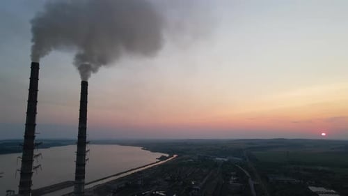 Luftbild der Hochrohre eines Kohlekraftwerks mit schwarzem Rauch, der sich nach oben bewegt und die verschmutzende Atmosphäre bei