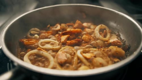 Professional kitchen in the restaurant seafood fried on a pan shrimp squid mussels salmon scallops
