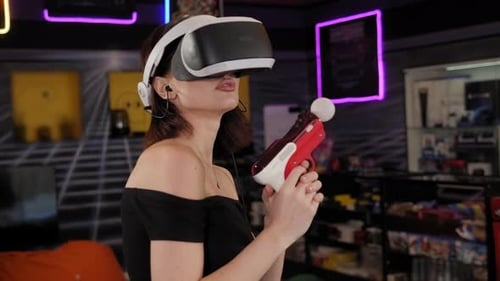 Woman Playing Game Using Virtual Reality Headset and Gamepads in the Game Club