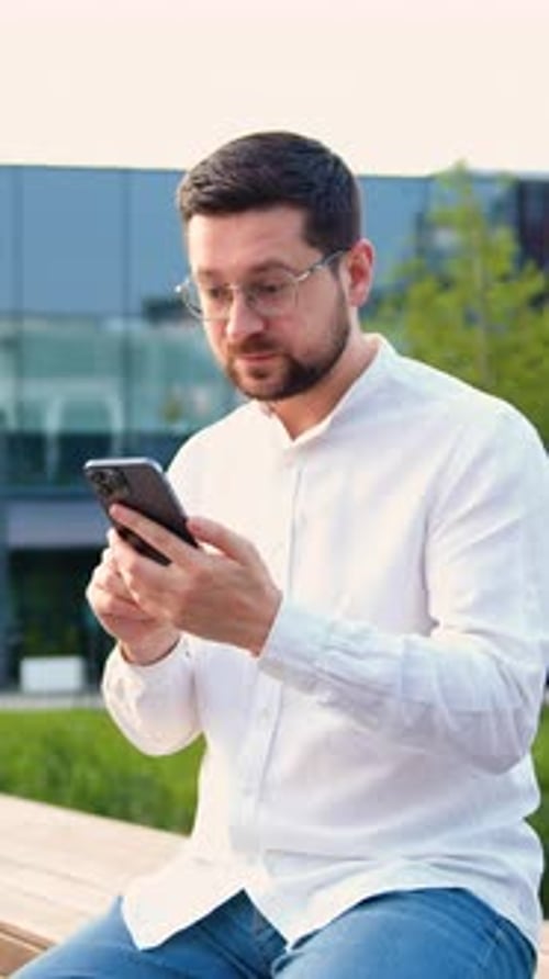 Excited Man Celebrates Good News on his Smartphone