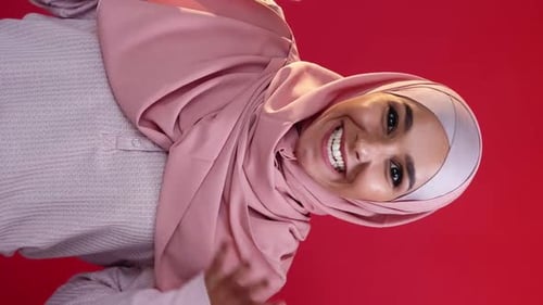Smiling Woman in Headscarf on Red Background