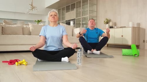 Mature Couple Meditating on Exercise Mats at Home